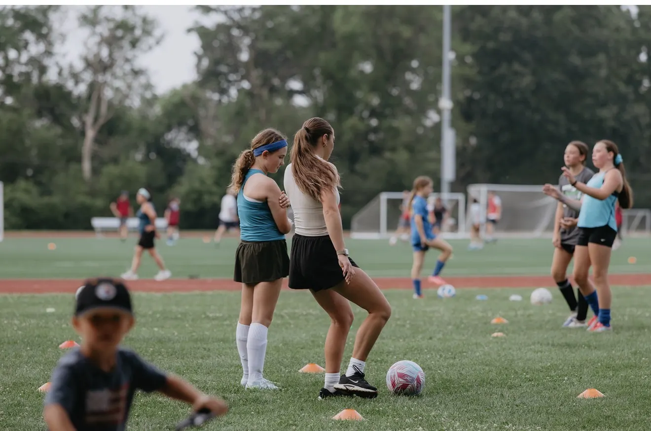 Mary running a soccer drill with young players